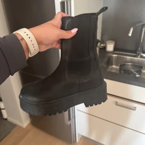 Svarta chunky  boots - Säljer dessa boots som aldrig är använda. Tror jag köpte de från Nelly