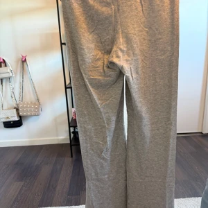 Grå mjukisbyxor från Gina Tricot - Hej, jag säljer dessa helt nya mjukisbyxorna från Gina Young i storlek 170 men har sytt dom för hand vid midjan där bak då resåret i byxorna var felsytt så klippte upp dom där bak och fixa det men det är ju inget man ser.