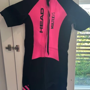 våtdräkt - Säljer en våtdräkt från HEAD i storlek M ock L. Använd en gång!  Kort våtdräkt som passar bäst för bröstsimmare, men som även kan användas för andra vattensporter. För bra slitstyrka är den nylonbeklädd både inuti och utanpå, och den har röd rygg för att du ska synas så bra som möjligt i vattnet.  Våtdräkt Damstorlekar