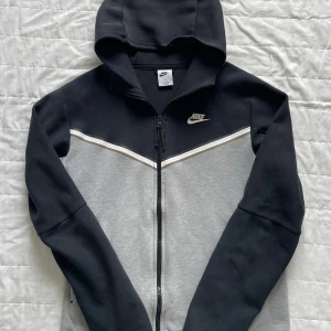 Nike tech fleece - Säljer min skitfeta nike tech fleece i färgen svart/grå. | Väldigt bra skick och fungerar som den ska. | Nypris 1200 kr ca. | Väldigt bekväm passar lika bra till gymmet som stan. | Storlek S. | Släng iväg en signal vid funderingar så svarar jag snabbt! |