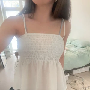 Vit somrig topp - Säljer en söt vit linnetopp med band som går att ta av så att det blir en tub topp. Perfekt för sommarn🫶🏻🫶🏻 TRYCK EJ PÅ KÖP NU