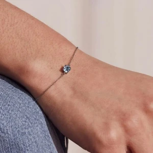 Tunt silverarmband med blå sten - Ett minimalistiskt armband i silver med en rund blå sten i mitten. Säljer då jag inte tycker om den på mig och aldrig använder 