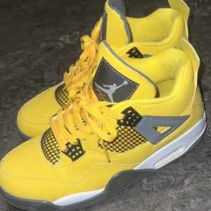 Nike Air Jordans i gul och svart - Säljer ett par Nike Air Jordans i en snygg gul färg med svarta och vita detaljer. Skorna har snörning, platt sula och klassisk mesh på sidorna. Perfekta för dig som vill sticka ut med dina sneakers!