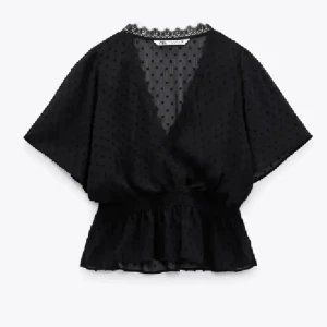 Svart blus från Zara  - Säljer en svart blus med v-ringning och spetskant vid halsen. Knappt använd 