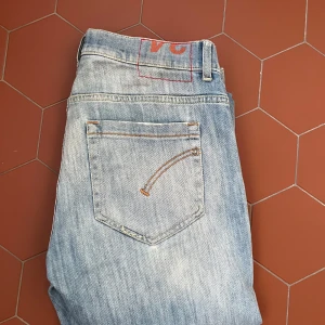 Ljusblå Dondups - Säljer ett par ljusblå jeansbyxor från Dondup med klassisk femficksdesign och slitningar på framsidan. Jeansen har broderad detalj på bakfickorna! Pris kan diskuteras!😎