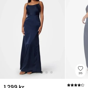 Marinblå långklänning i satin - Elegant marinblå långklänning i glansigt satinmaterial med smala axelband och figurnära passform. Perfekt för speciella tillfällen när du vill känna dig extra fin. Använd 1 gång 