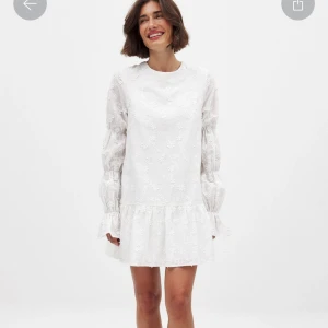 Vit blommig klänning  - Säljer en vit klänning med broderade blommor, volangdetaljer och lång ärm. Klänningen har öppen rygg med knytband och en lös passform. Perfekt för vår och sommar! Klänningen är aldrig använd, enbart testad!! Super fin och väldigt populär och trendig klänning från Nakd som tyvärr inte kommer komma till användning. Perfekt inför studenten!! Nypris 699, mitt pris 669 men det kan diskuteras 