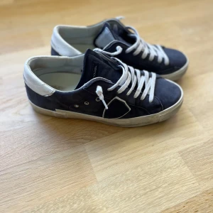 Philippe Model skor - Säljer ett par snygga Philippe Model skor  i mörkblå mocka med vita detaljer och vit sula i storlek 39 men passar 40! De är i 8/10 skick men sliten sula! Kom privat för mer info