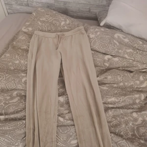 Beige mjukisbyxor från Divided - Beiga mjukisbyxor från Divided i supermjuk och stretchig polyesterblandning. Byxorna har dragsko i midjan och raka ben. Perfekta för en avslappnad stil och riktigt sköna att ha på sig.