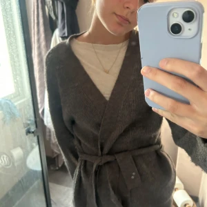 Brun stickad tröja - Mysig brun stickad cardigan med knytbälte i midjan och lång ärm. Perfekt, har en avslappnad, lite oversized passform. Enkel att matcha med olika outfits.