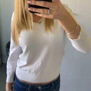 Vit stickad tröja med v-ringning  - Säljer en enkel och stilren vit stickad tröja med v-ringad hals. Tröjan har långa ärmar och en klassisk passform som passar till mycket. Perfekt basplagg i garderoben. 💞