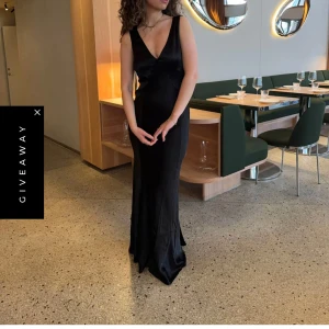 Svart satin klänning  - Svart satin klänning från Design by Si i storlek XS/S  Säljer en helt oanvänd långklänning i satin från Design by Si med prislappen kvar. Den är i storlek XS/S och har drapering i ryggen. Klänningen är figurnära och faller hela vägen ner till fötterna, jag är 173 cm lång och den passar perfekt i längd.  Nypris: 823 kr 