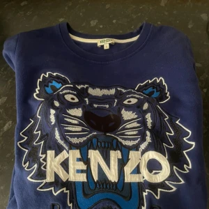 Blå sweatshirt från Kenzo - Säljer en blå sweatshirt från Kenzo. Tröjan har rund halsringning och är i mjukt material.