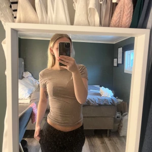 Beige tight t-shirt - Säljer en beige tight t-shirt med rund halsringning. T-shirten är kortärmad och har en enkel, stilren design utan mönster eller detaljer. Perfekt basplagg till garderoben.