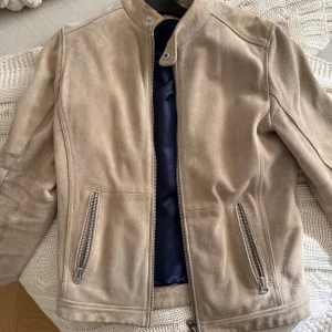 Beige mockajacka - Säljer en stilren beige mockajacka från Human Scales. Väldigt fint skick, känns lyxig. Säljes då den är för liten för mig. 