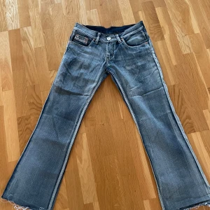 Lådmidjade bootcut jeans från Buddy - Säljer ett par lådmidjade blå bootcut jeans från Buddy. Kommer tyvärr inte till användning längre. Lappen på ena fickan har gått av på ena kanten (se sista bild) men går lätt att sy fast eller klippa bort om man vill.💗