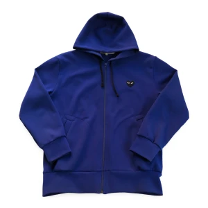 Blå hoodie från Comme des Garçons Play - Säljer en blå hoodie med dragkedja från Comme des Garçons Play. Tröjan har huva med snörning, fickor fram och ett svart hjärta med ögon på bröstet samt en stor hjärtdetalj på ryggen.