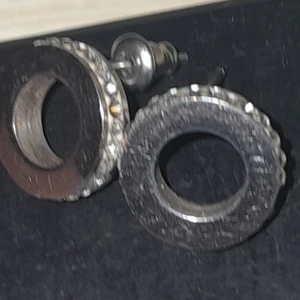 Edblad Runda örhängen i silver och svart - Edblad Snygga runda örhängen med en kombination av silver och svart. De har en modern design med en cirkulär form och en stilren look. Perfekta för att ge en elegant touch till din outfit.