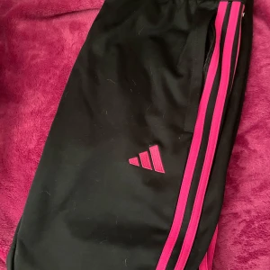 Svart/rosa träningsbyxor från Adidas - Snygga svart/rosa träningsbyxor från Adidas. Storlek 34 , för små för mig