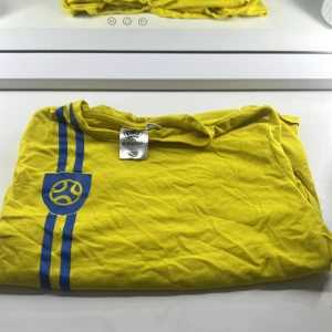 Gul Sverige fotbollströja UEFA Euro 2020 - Säljer en gul fotbollströja med blå detaljer från UEFA Euro 2020. Tröjan har korta ärmar och texten 'Sverige' på baksidan. Perfekt för fotbollsfans som vill visa sitt stöd för Sverige. Köpte den från Lidl 250kr 5 år sen. har använt den 3 gånger. Priset kan diskuteras 