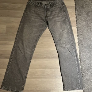 Grå jeans från Jack & Jones - Snygga grå jeans från Jack & Jones med en klassisk straight fit. Perfekta för en avslappnad stil. De har fem fickor och en knappgylf.  Dem är förhandlingsbara!