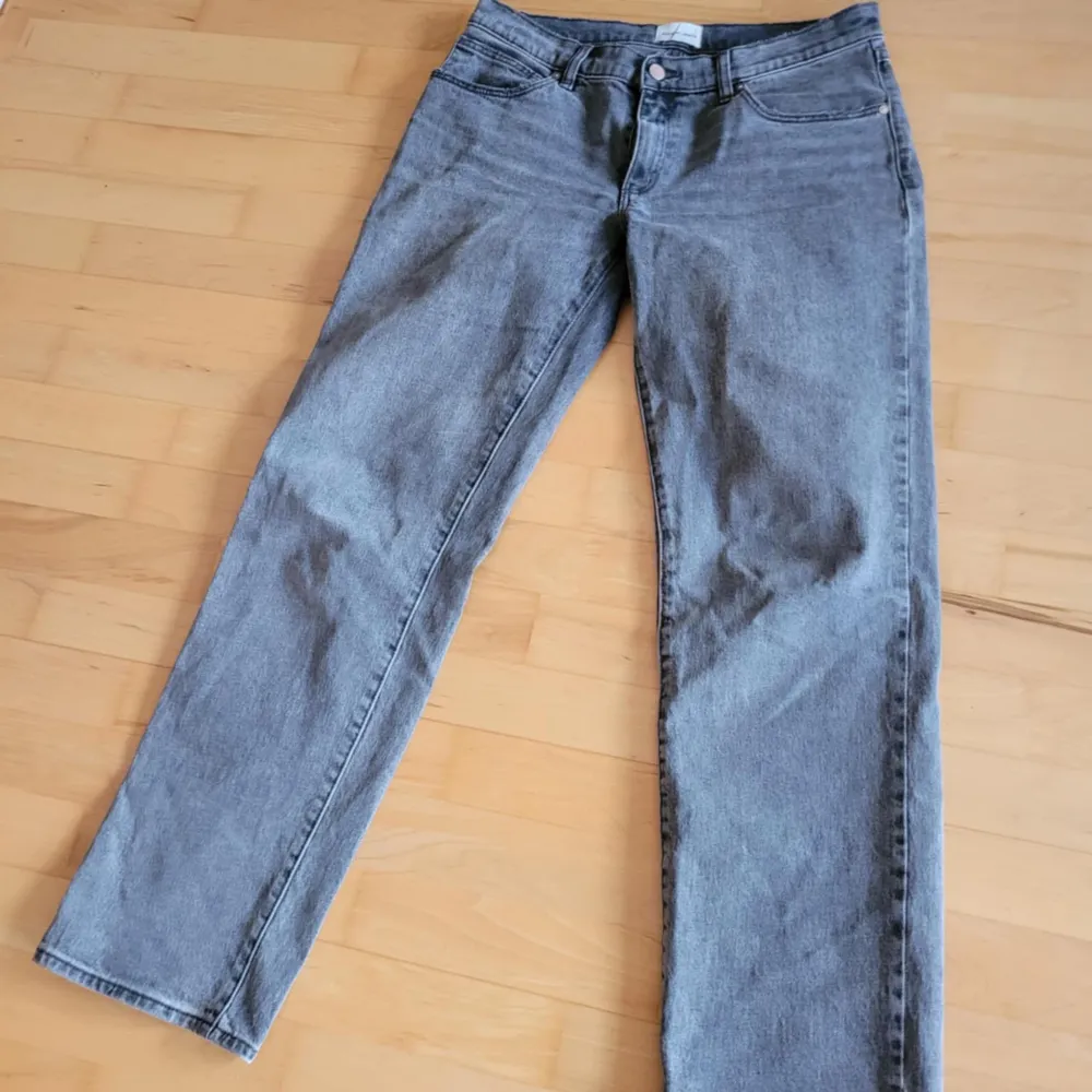 Snygga grå jeansbyxor med klassisk femficksdesign och knappgylf. De har en rak passform och är perfekta för en avslappnad stil. Märkesdetalj på bakfickan ger en extra touch.. Farkut & Housut.