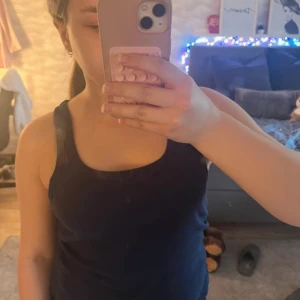 Mörkblå linnetopp från Lager 157 - Säljer en mörkblå linnetopp från Lager 157 i mjuk bomull. Perfekt för varma dagar eller som lager under en tröja. Enkel och stilren design med breda axelband.