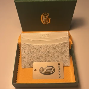 Cool vit korthållare  - Elegant vit plånbok med ett ikoniskt mönster. Den har flera fack för kort och en stilren design. Perfekt för att hålla dina kort organiserade med stil.💯 Bara att höra av sig vid eventuella frågor😊