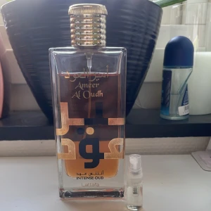 Lattafa Ameer Al Oudh + 5ml sampel present - Säljer en elegant parfymflaska från Lattafa, Ameer Al Oudh Intense Oud. Doften är en blandning mellan swy intensely och by the fire place. Perfekt för den som älskar intensiva och rika dofter. Kommer med 5ml sampel present🎁 