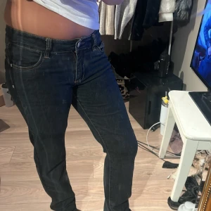 Mörkblå jeansbyxor - Snygga mörkblå jeansbyxor med en klassisk femficksdesign och knappgylf. Perfekta för en avslappnad stil. De har en normal passform och är tillverkade i ett slitstarkt denimtyg.