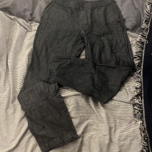 Gråblå Uniqlo linnebyxor  - Gråblåa brallor i linne/bomullsblend från Uniqlo. Perfekta för sommaren som kommer :). Har använts 4-5 ggr. Storlek M, W30-33 (drawstrings på insidan), nypris 599 kr, kom med bud eller ta dem för 250.