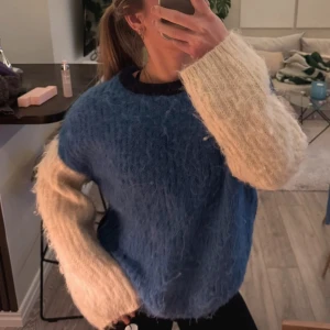 Blå och vit fluffig tröja från arket - Säljer en supermysig blå och vit fluffig tröja med långärmade kontrastfärgade ärmar. Perfekt för kyliga dagar när du vill vara både varm och stilren. Tröjan har en normal passform och är gjord i ett mjukt material som känns skönt mot huden. Ett måste för garderoben! 💙🤍