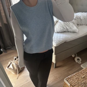 Ljusblå stickad väst - Säljer en ljusblå stickad väst med rund halsringning. Perfekt att bära över en långärmad tröja för en stilren look. Inga tecken på användning. tycker sådana här är så fina men passar inte mej tyvärr!! hör av dej❤️