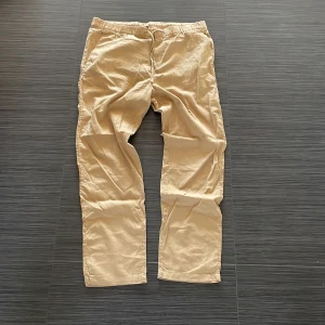 Beige linnebyxor från H&M - Säljer ett par bekväma beige linnebyxor från H&M med elastisk midja och snörning. Perfekta för en avslappnad stil. Byxorna har en rak passform och är tillverkade i ett lätt och luftigt material.