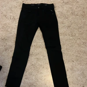 Svarta jeans från Replay - Snygga svarta jeans från Replay Hyperflex-serien. De har en slim passform och är perfekta för en stilren look. Byxorna har klassisk femficksdesign och en knappgylf.