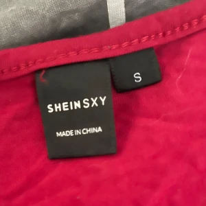 Röd klänning från Shein SXY - Snygg röd klänning från Shein SXY i en smickrande lång modell. Klänningen har långa ärmar och är perfekt för en elegant look. Tillverkad i ett mjukt och bekvämt material. Använt 2 gånger den är klippt för den var för lång på mig ” 152cm” 