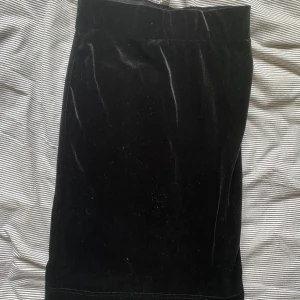 Sammetskjol  - Svart sammetskjol från bik bok som går ned till knäna