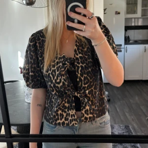 Leopardmönstrad blus från Neo Noir - Trendig leopardmönstrad blus från Neo Noir med korta puffärmar och knytning framtill. Aldrig använd och har prislappen kvar!🐆