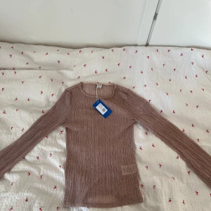Rosa glittrig topp från Gina Tricot - Säljer en snygg rosa glittrig topp från Gina Tricot. Toppen har långa ärmar och en smickrande passform. Perfekt för att lägga till lite glitter i vardagen. Hör av dig vid intresse! ✨