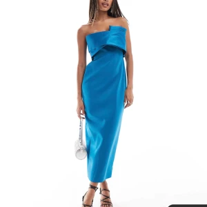 Blå axelbandslös klänning - Snygg blå axelbandslös klänning med en elegant slits bak. Perfekt för en kväll ute eller en speciell tillställning. Klänningen har en stilren design med en unik detalj framtill. Klänningen är från asos och säljer den då jag missade att returnera den. Prislapp finns kvar på aldrig använt, helt ny blå klänning i storlek 34. köpt för 1069kr säljer för 800kr