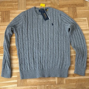 Stickad polotröja: Oanvänd  - Stilren och klassisk polo stickad i mjukt och värmande material. Tröjan är helt oanvänd och i nyskick - perfekt för både vardag och finare tillfällen. Tidlös design med högre krage och ribbade muddar för en bekväm passforrm. Storleklek XS, men passar även dig som har S tack vare den flexibla modellen. Snabba affärer kan diskuteras!