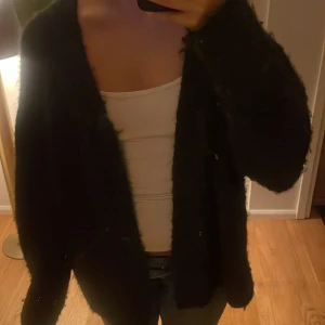 Mörk grå stickad kofta - Säljer en mysig svart kofta med lång ärm. 