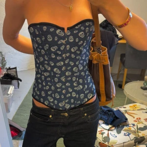 Mörkblå korsett med dödskallemönster - Snygg mörkblå korsett med ett coolt dödskallemönster.  Justerbar men skulle säga storlek XS/M. Fint skick.💓