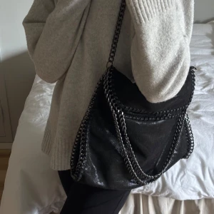 Svart axelväska med kedjedetaljer - stella mccartney liknande väska, stor och rymlig men kommer tyvärr inte till användning 