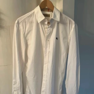 Burberry skjorta - En vit burberry skjorta i storlek L, skjortan är i bra skick och har inga fläckar eller märken. Billigare vid snabb affär, ej hugget i sten!