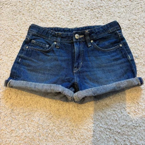 Blå jeansshorts - Snygga blå jeansshorts med uppvikta kanter från h&m. Storlek 11 år men skulle säga passa en xxs 