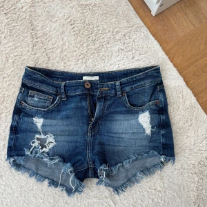 Lågmidjade jeansshorts från hm - Säljer ett par lågmidjade mörkblå jeansshorts från H&M med slitna detaljer. Inga defekter💕💕