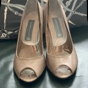 Beige peep-toe pumps med klack 37 nya  - Säljer ett par stilrena beige pumps med öppen tå och hög klack. Skorna har en klassisk form och är perfekta för dig som vill ha en elegant 