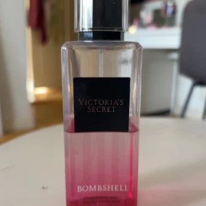 Victoria's Secret Bombshell Body Mist - Fräsch och feminin body mist från Victoria's Secret i doften Bombshell. Flaskan är genomskinlig med rosa botten och svart lock. Perfekt för dig som gillar fruktiga och blommiga dofter.