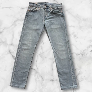 Levi's 502 ljusblå jeans 29/32 - Säljer ett par klassiska Levi's 502 jeans i ljusblå tvätt. Jeansen har rak passform, fem fickor och ikoniska detaljer som läderpatch och röda Levi's-taggen bak. Perfekta för en avslappnad stil och funkar året runt.